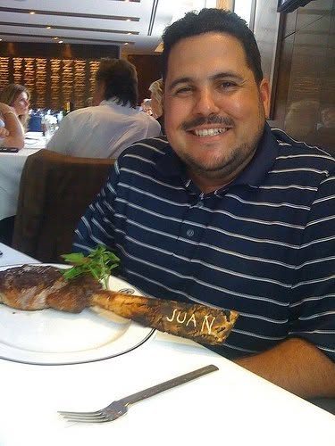 Juan at a restaurant with a steak whose bone has JUAN written on it