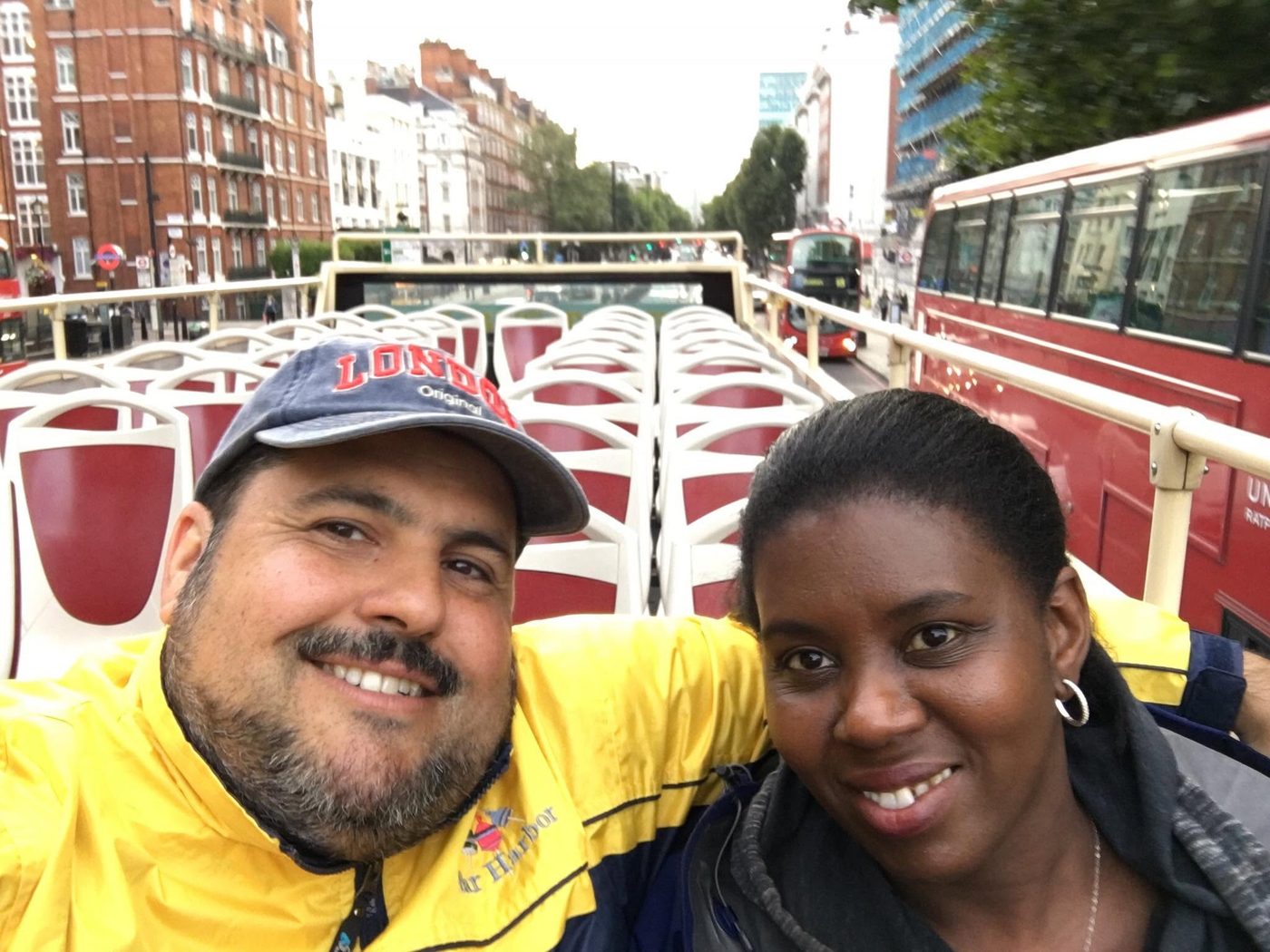 Juan and a woman taking a selfie on the top deck of a tour bus