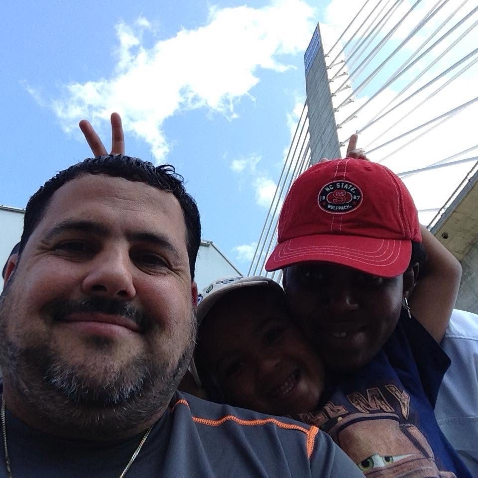 Juan's selfie with a woman and a child behind him, one giving him bunny ears