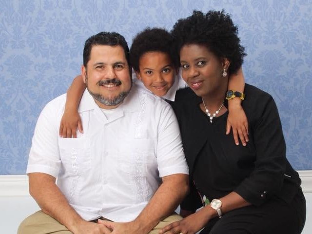 Juan today in a studio portrait with a woman and a child
